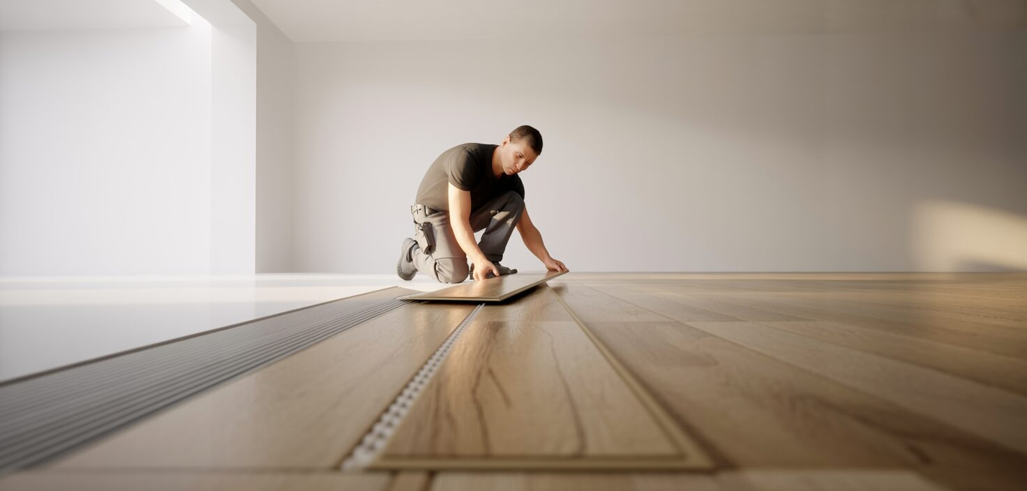 En professionell golvläggare installerar ett klickgolv i ett minimalistiskt rum med rent ljus och fokus på detaljer.